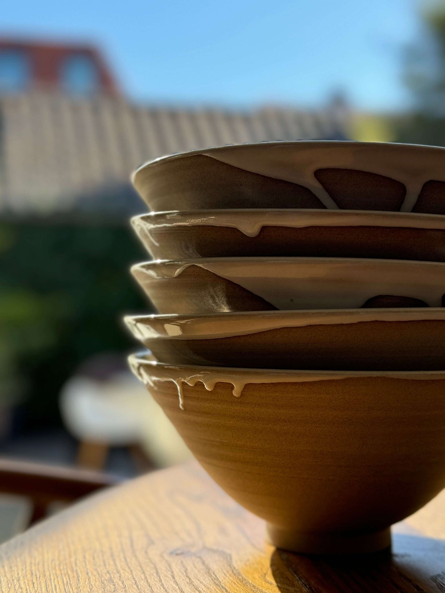 Stack of Yuki Series ramen bowls with glossy white glaze inside and raw toffee clay outside, showcasing elegant, functional design.