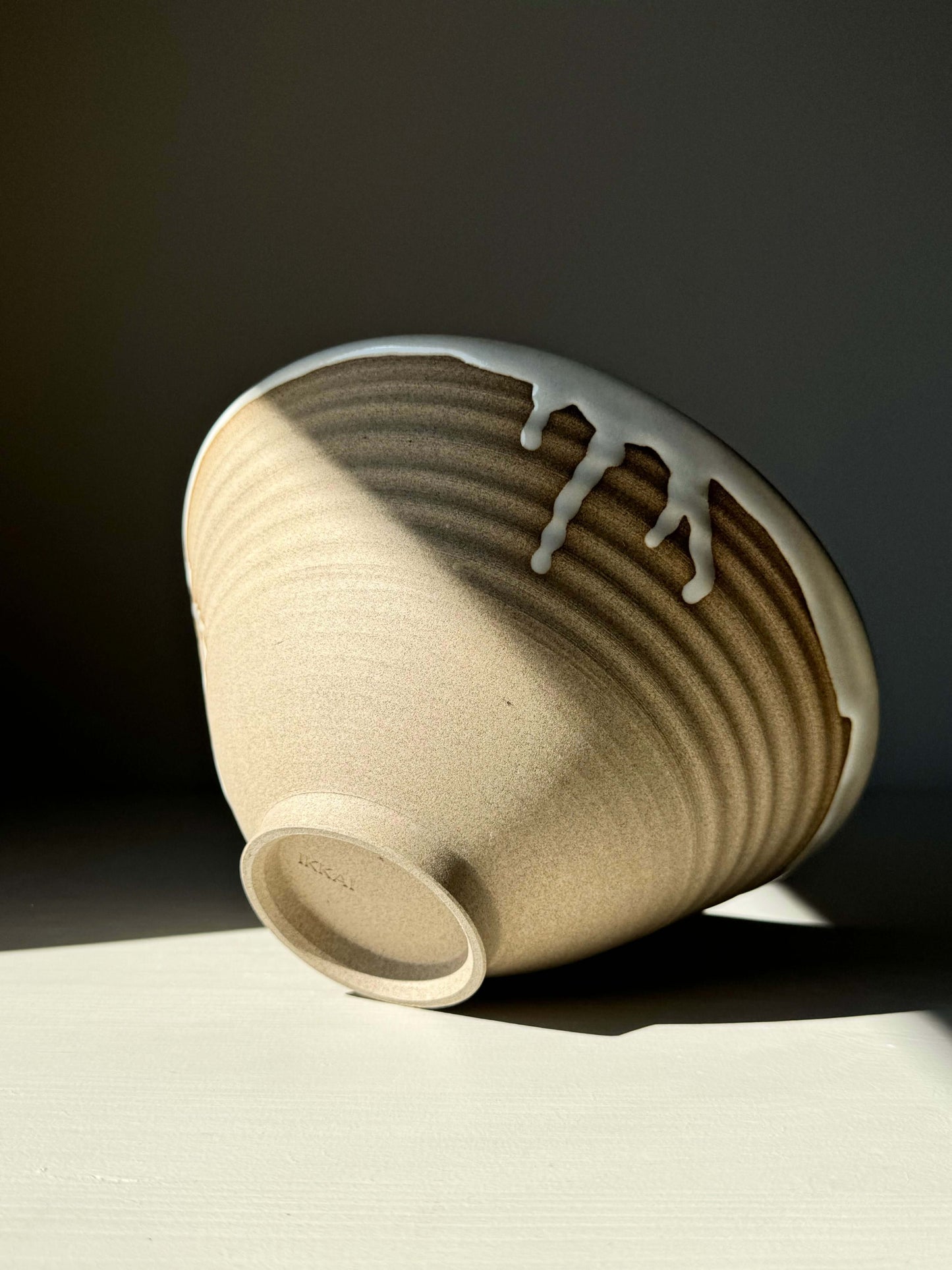 Elegant Yuki Series ramen bowl with glossy white glaze and raw toffee clay, showcasing its unique, rounded design and gentle curve.