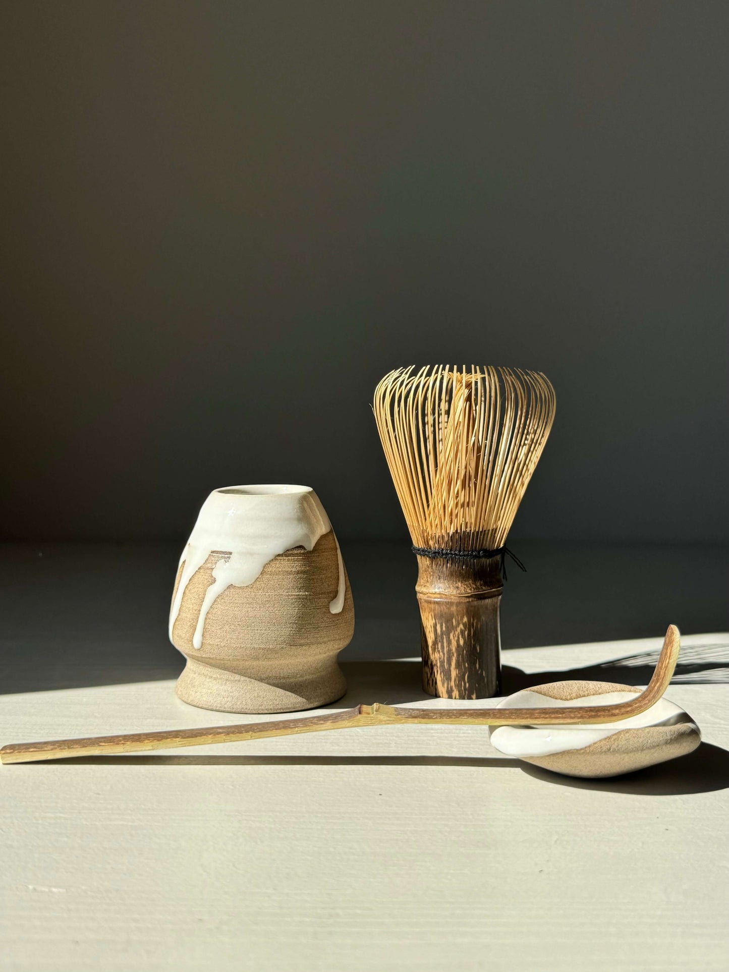Rounded chopstick and matcha spoon rest with whisk from Yuki Series, featuring white glaze and raw clay for a calm aesthetic.