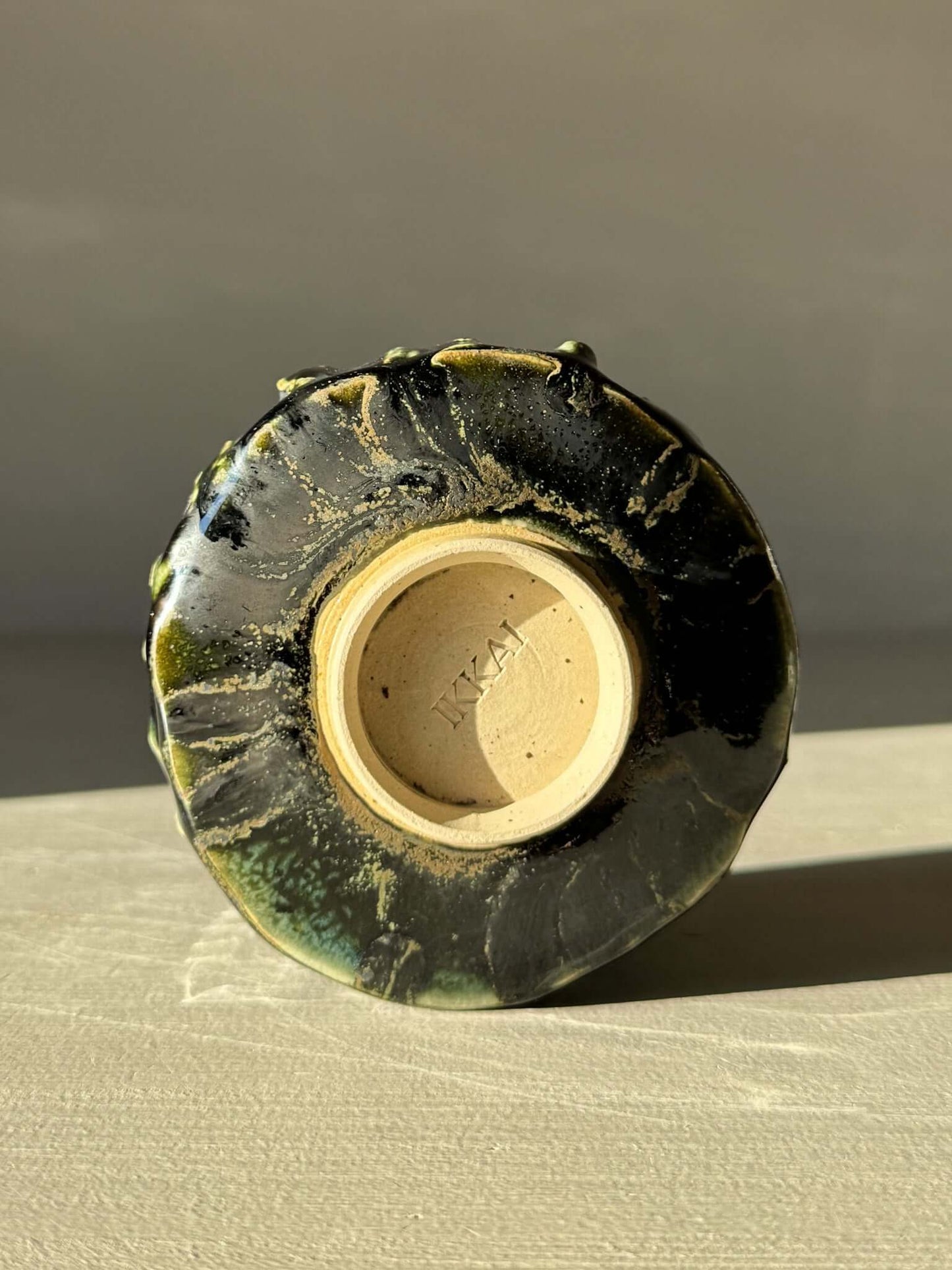 Bottom view of Yunomi Cup - Hinoki #11 showcasing hand-decorated slip texture and deep green glaze detail.