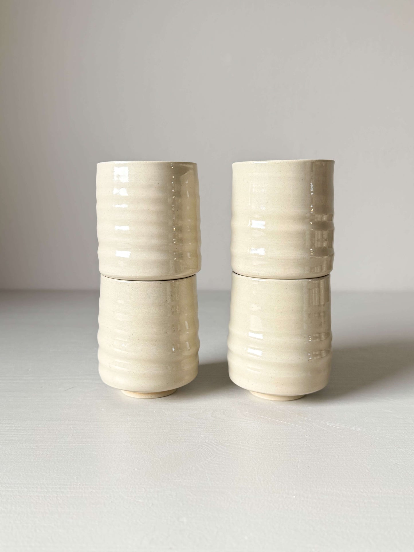 Set of four clear glazed stoneware Yunomi cups, showcasing elegant craftsmanship and compact, refined design.
