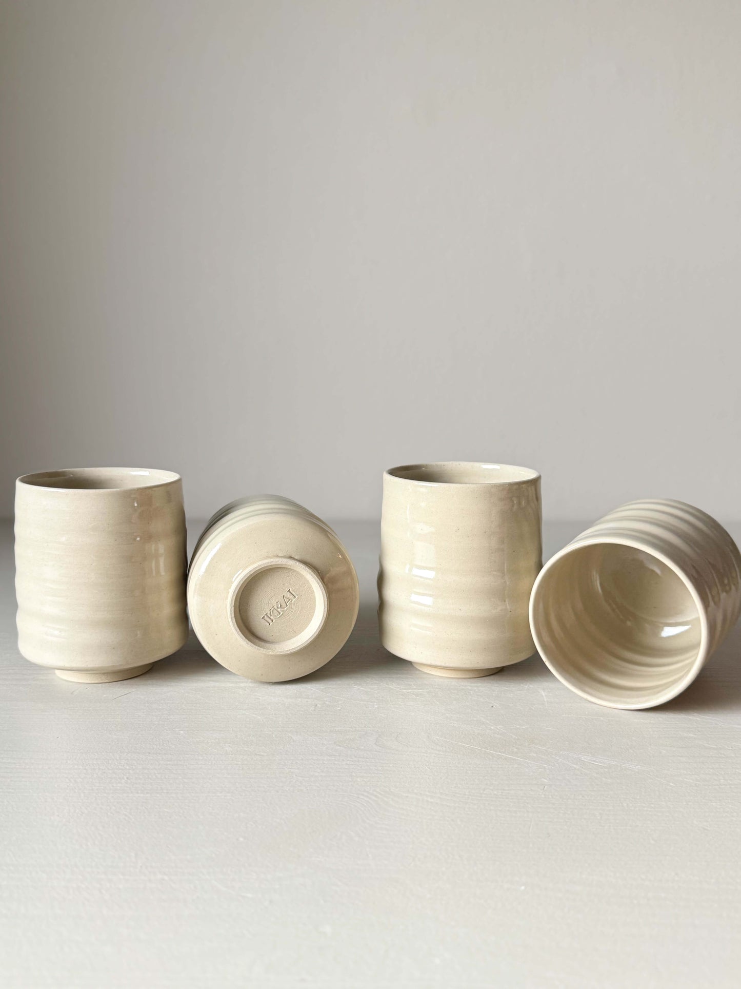 Wheel-thrown Yunomi cups with clear glaze finish on display, crafted from high-fired stoneware clay, showcasing elegance and simplicity.