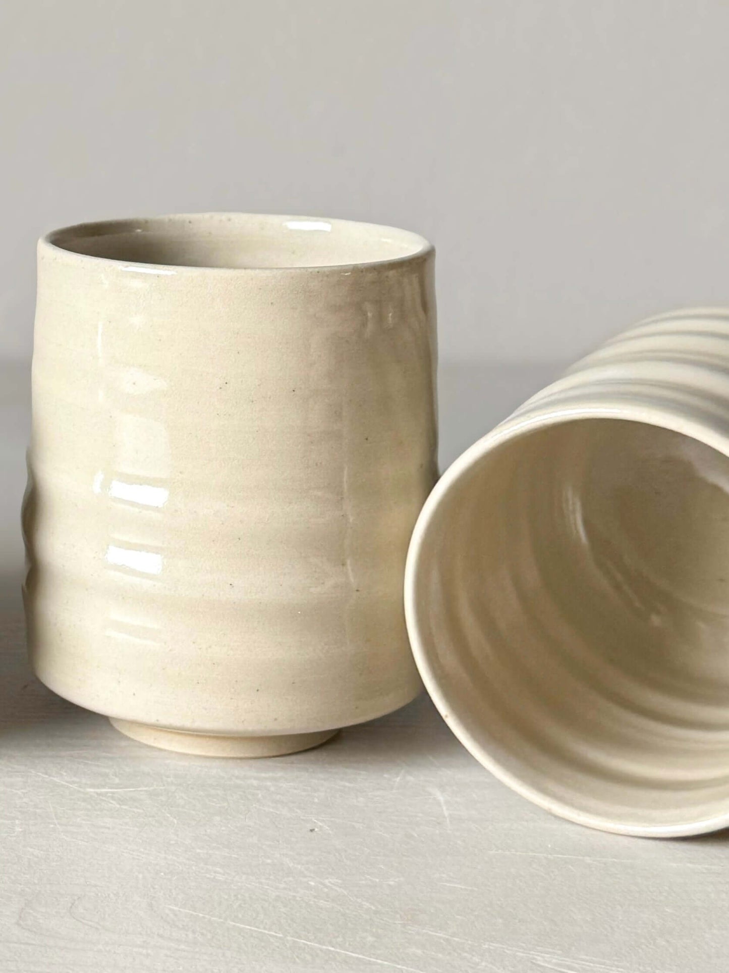 Wheel-thrown Yunomi cups with clear glaze showcasing the natural beauty of high-fired stoneware clay, compact and elegant design.