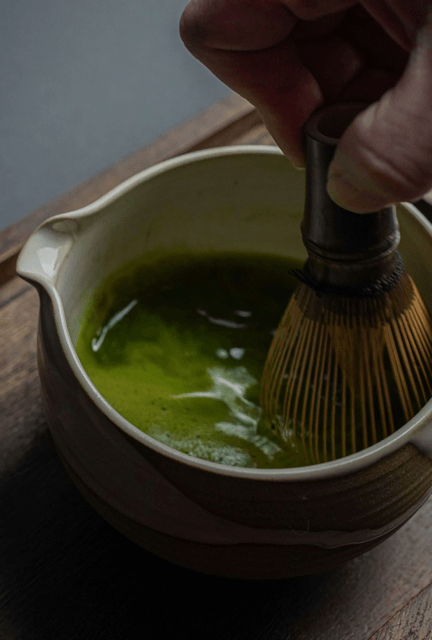 Whisking matcha in a handmade ceramic bowl with a bamboo whisk, IKKAI Ceramics