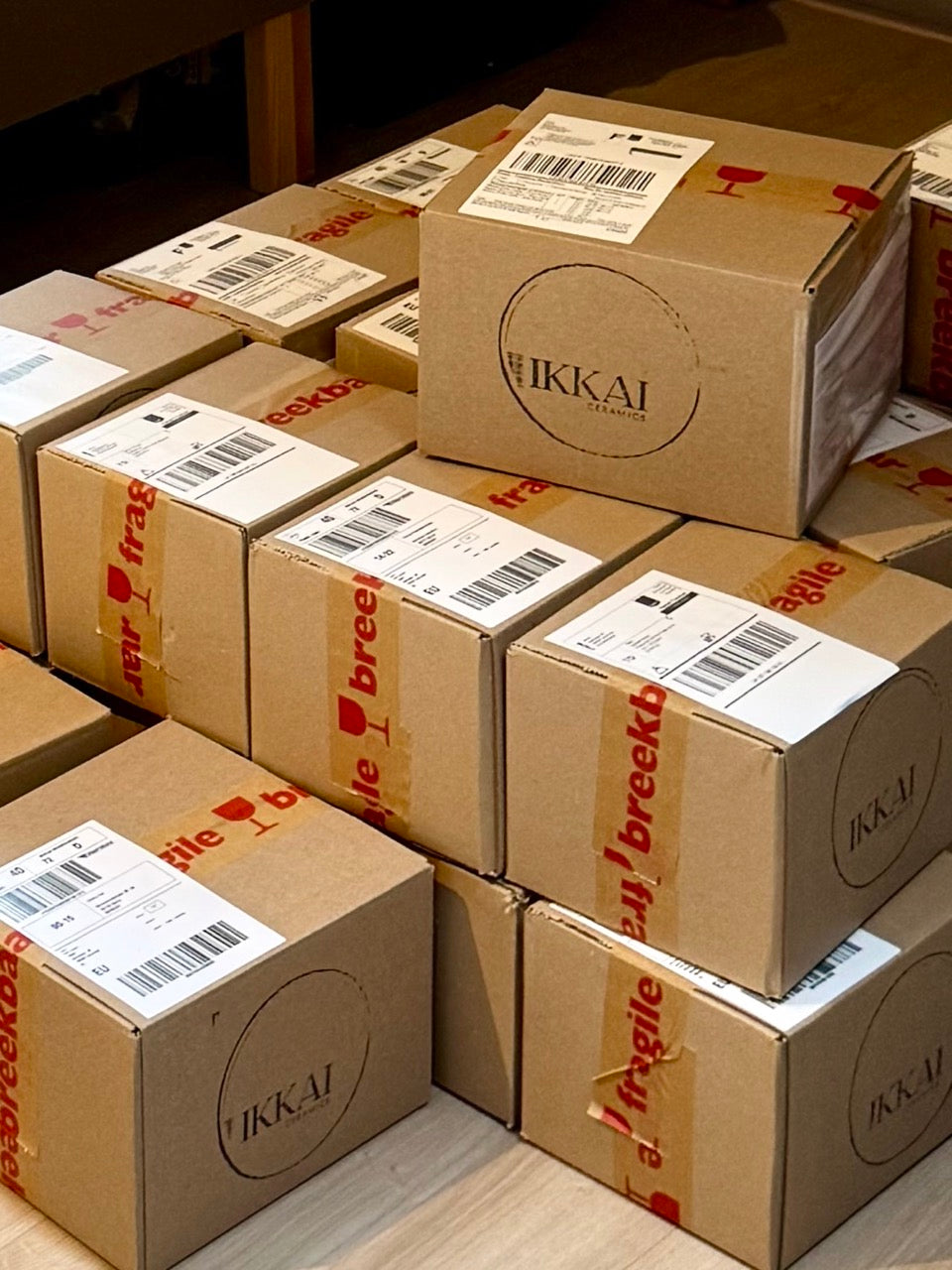How to ship pottery – stacked IKKAI Ceramics parcels with fragile tape and shipping labels, ready for dispatch
