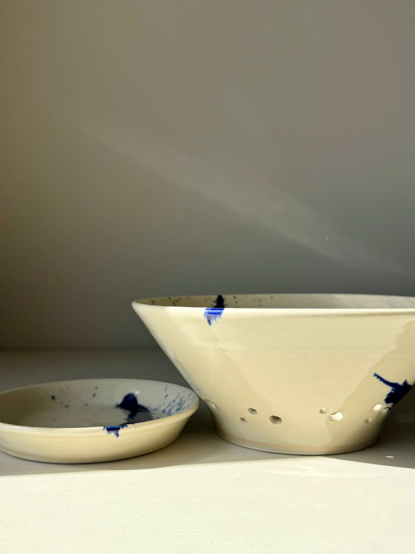 Sculptural berry bowl from Gosu Series with cobalt blue splashes and matching drip plate for rinsing fresh fruit.