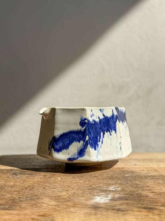 Faceted Matcha Bowl with Spout in cobalt blue and glossy white glaze, showcasing a modern design on a wooden surface.