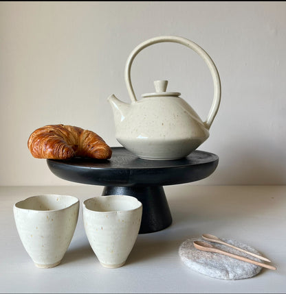 handmade ceramic teapot and cups with small wooden teaspoons