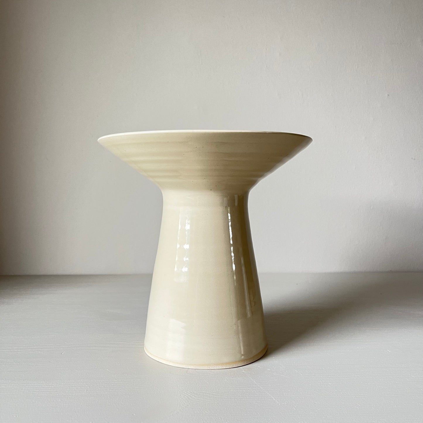 a large cream ceramic pedestal candlestick holder