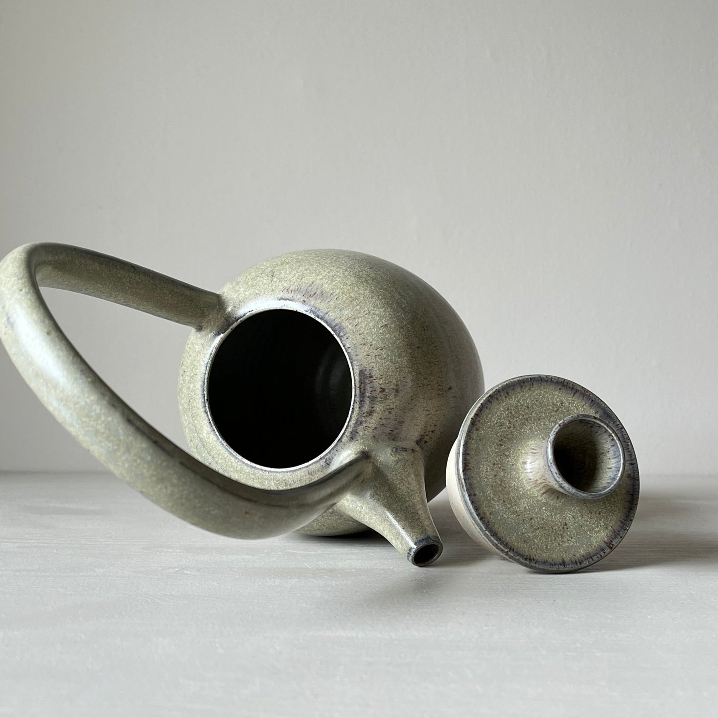 inside view of a blue ceramic teapot on a neutral background