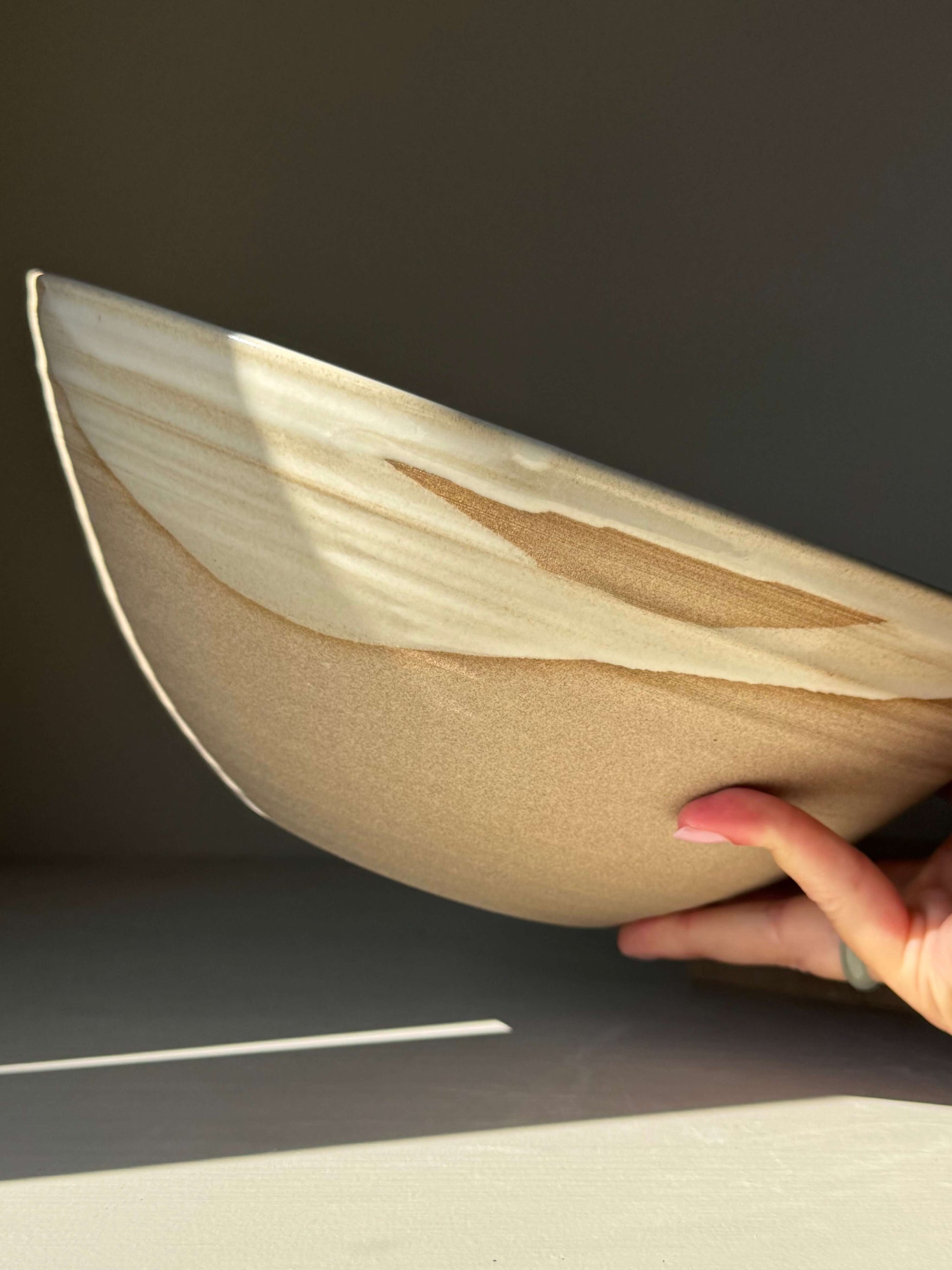 Handmade ceramic Large Bowl - Yuki Series with white glaze over raw clay, highlighting its deep, rounded form in natural light.