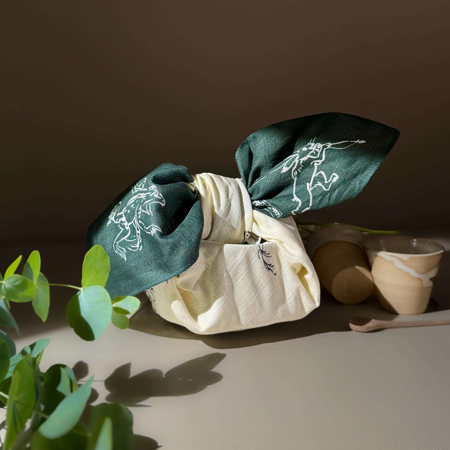 Medium Furoshiki Round Window Green tied with decorative green fabric, featuring animal designs on a light background.