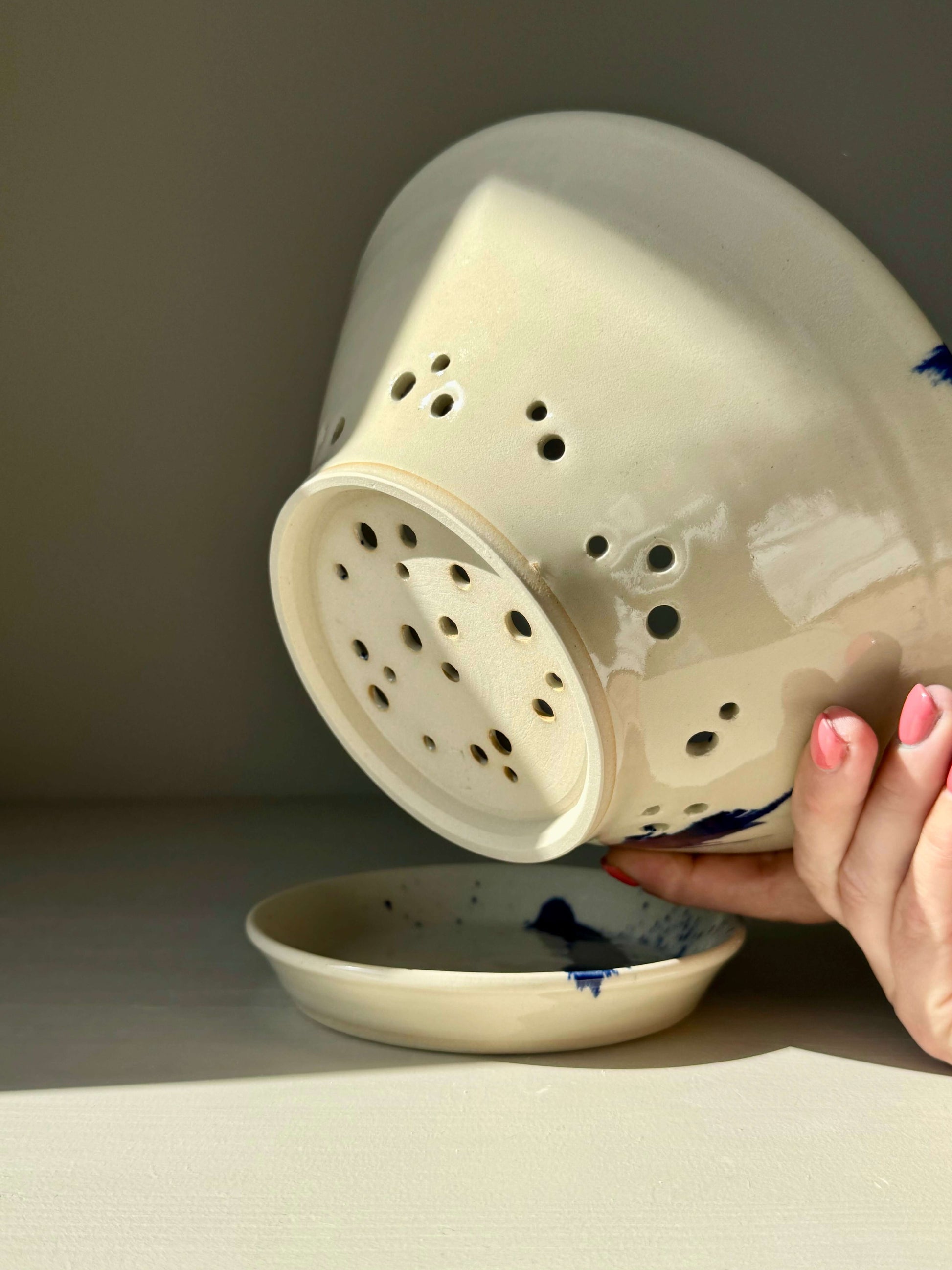 Sculptural berry bowl from the Gosu Series #02 in clear glaze with blue splashes, shown with matching drip plate.
