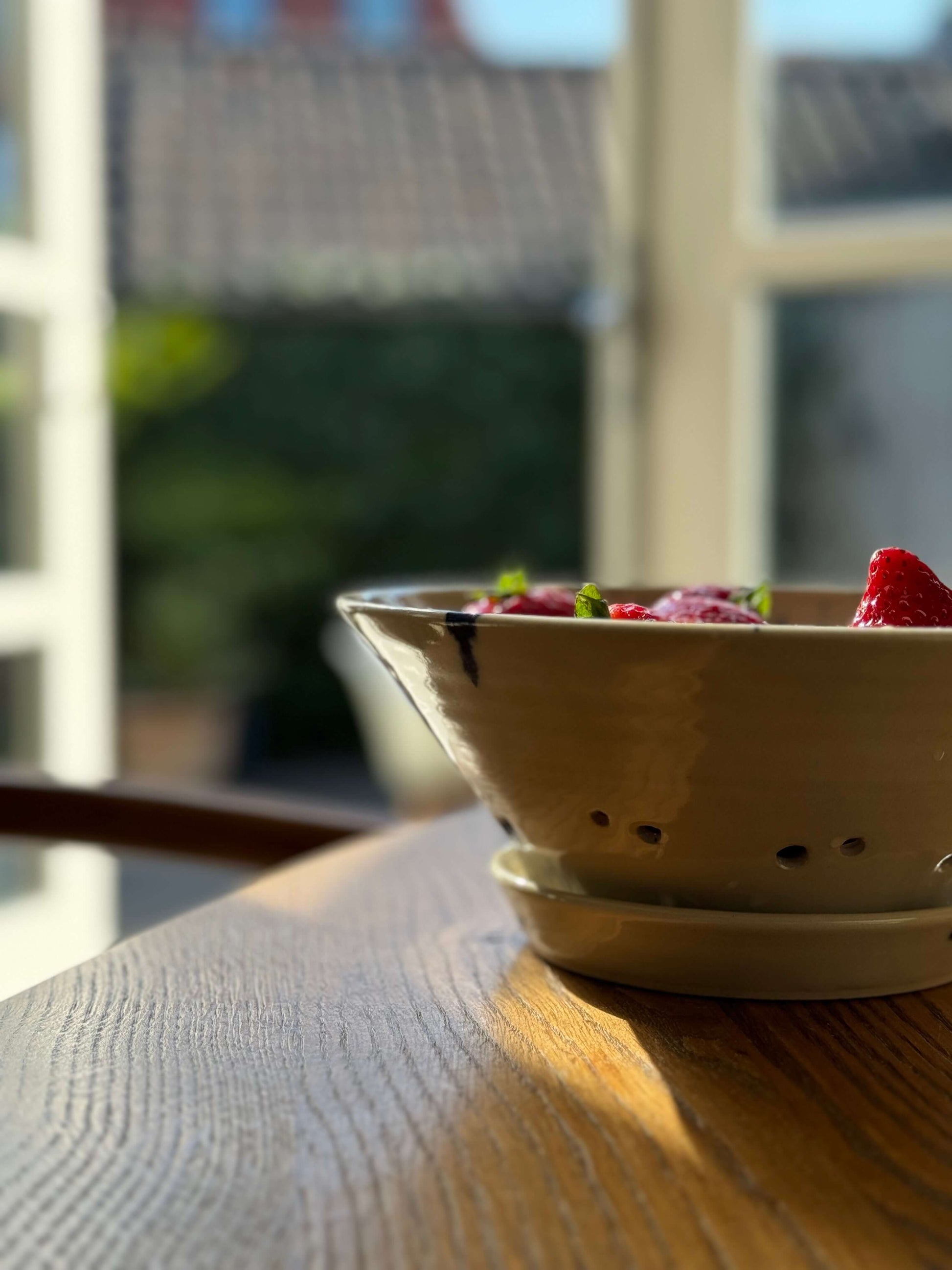 Berry Bowl from Gosu Series #02 with cobalt splashes, filled with strawberries, placed on a table in natural light.