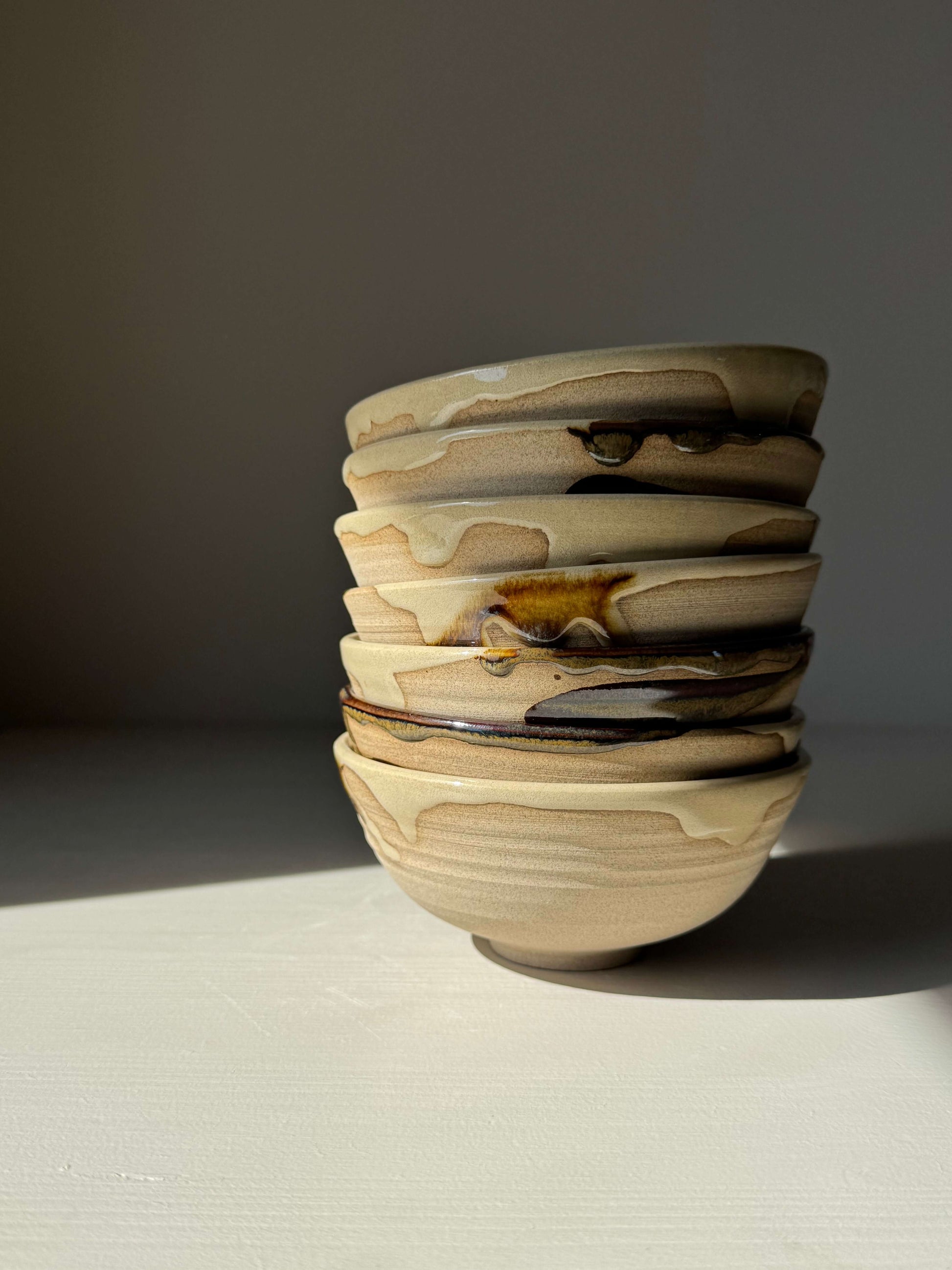 Handmade ceramic Small Bowl - Inyo Series with tenmoku glaze, stacked, showcasing duality in form and texture on a neutral background.