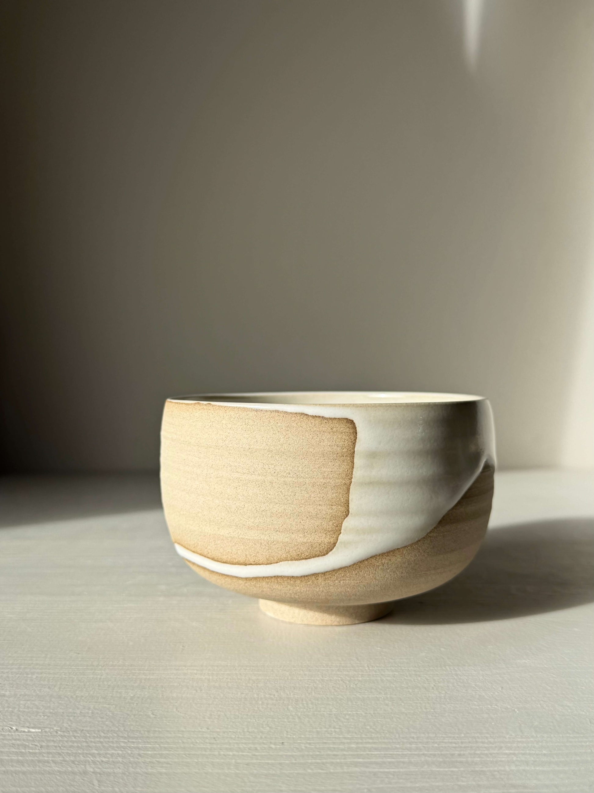 Matcha Bowl – Yuki #04, handmade ceramic bowl with toffee clay and glossy white glaze, showcasing unique wheel-thrown design.