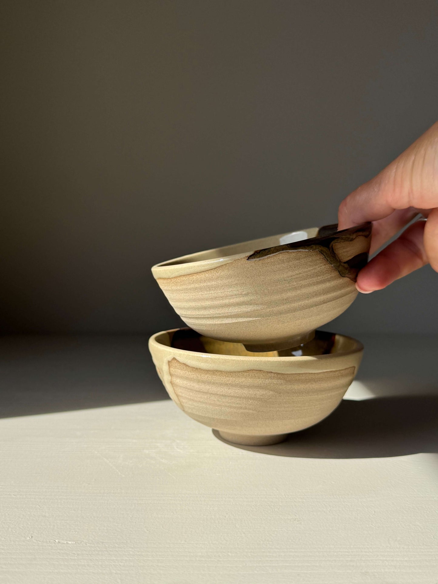 Handmade ceramic Small Bowl - Inyo Series with flowing tenmoku glaze, showcasing balance and contrast in earthy tones.