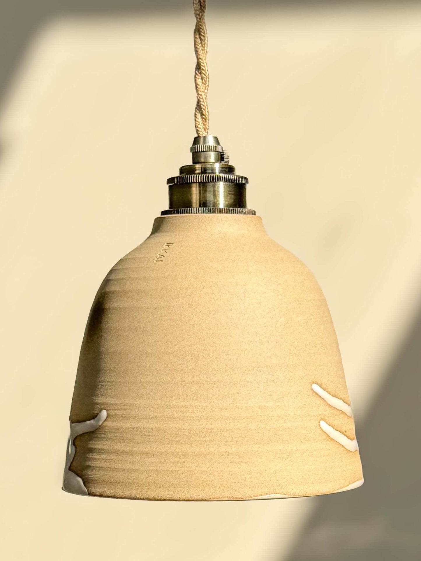 Elegant Ceramic Lamp Shade – Yuki #04 with glossy white interior and warm clay exterior, showcasing unique design and soft lighting.