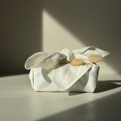 Small present wrapped in a cream furoshiki