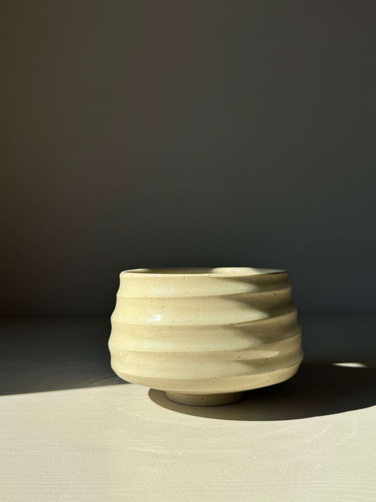 Textured rounded matcha bowl with clear glaze, showcasing natural stoneware beauty and tactile ridges, perfect for tea rituals.