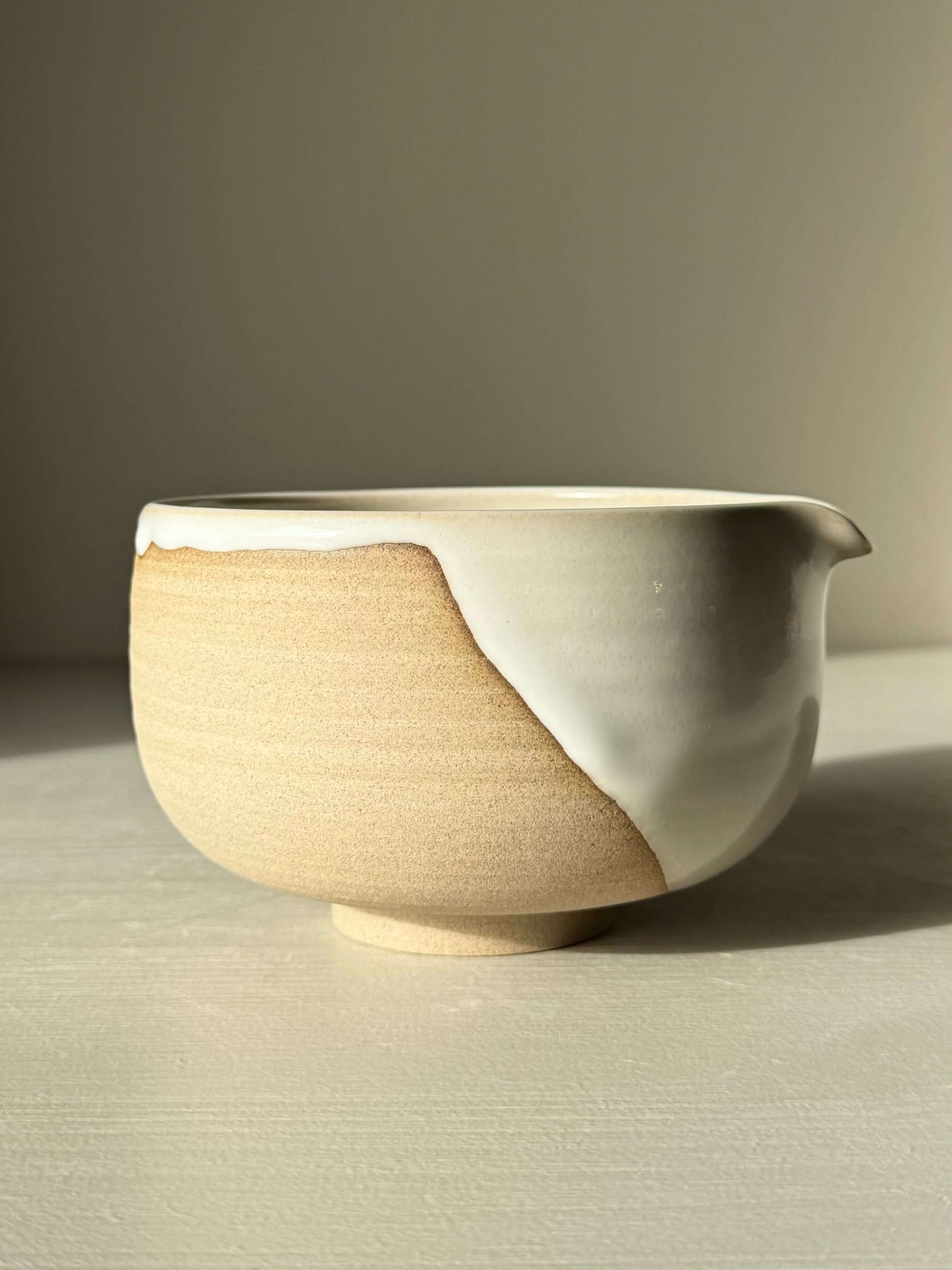 Handmade ceramic Matcha Bowl with Spout – Yuki #02, featuring toffee clay and white glaze, crafted in a home studio setting.