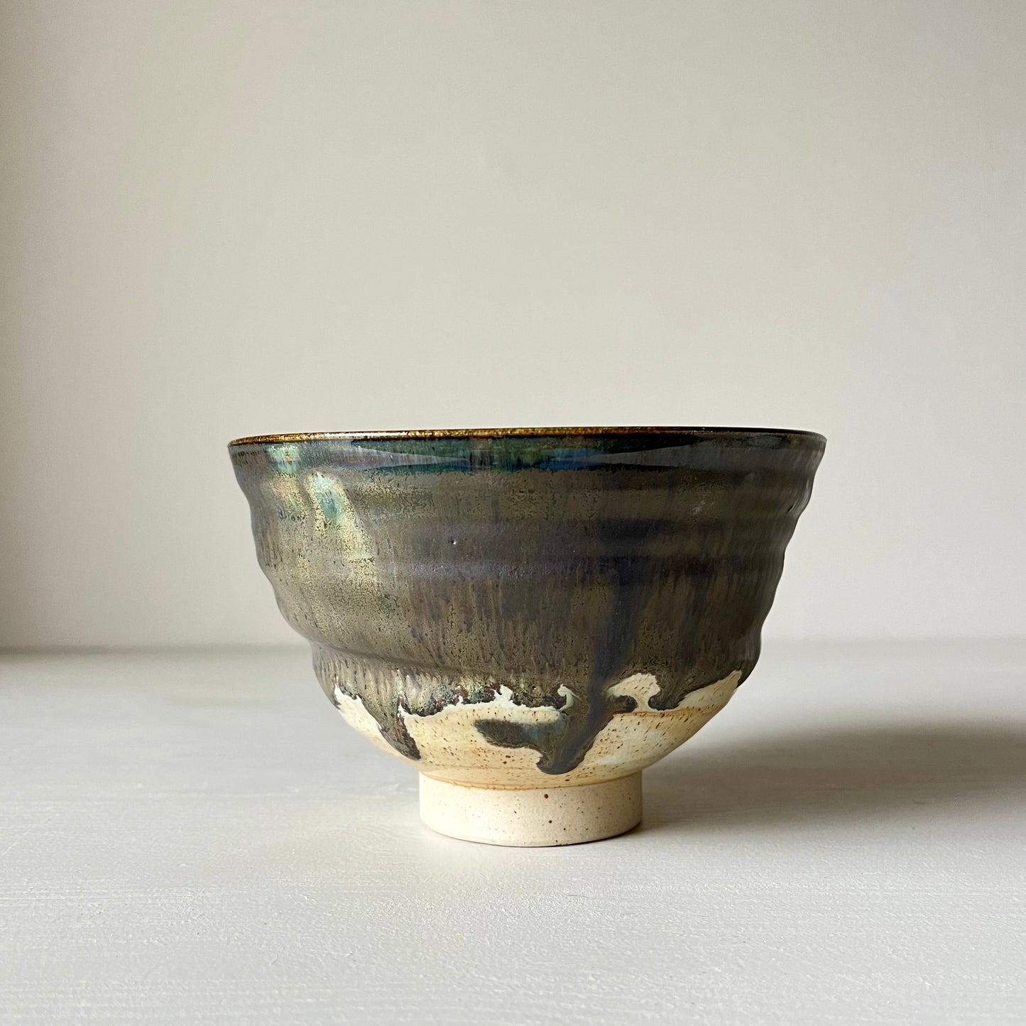 a black and cream ceramic matcha bowl on a neutral bowl 