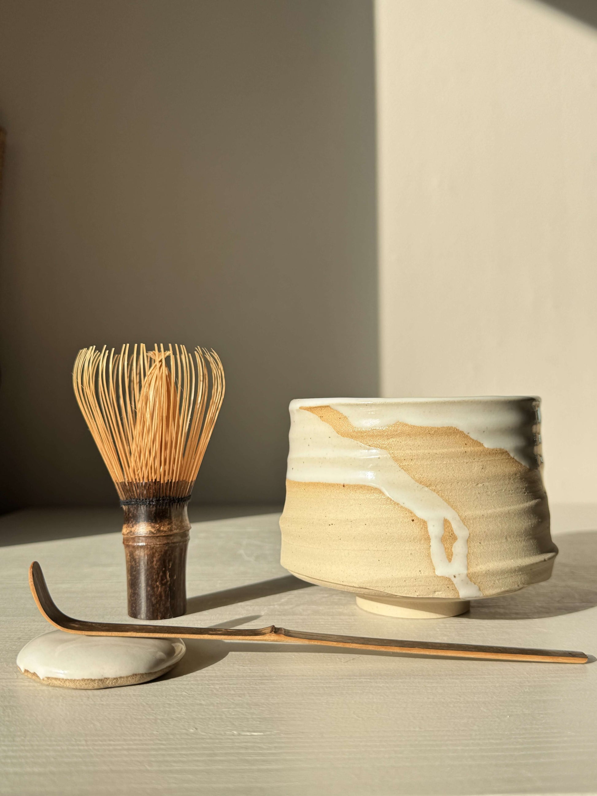 Matcha Bowl – Half Glossy White Glaze #02 handmade ceramic with whisk and scoop detail, tactile surface visible.