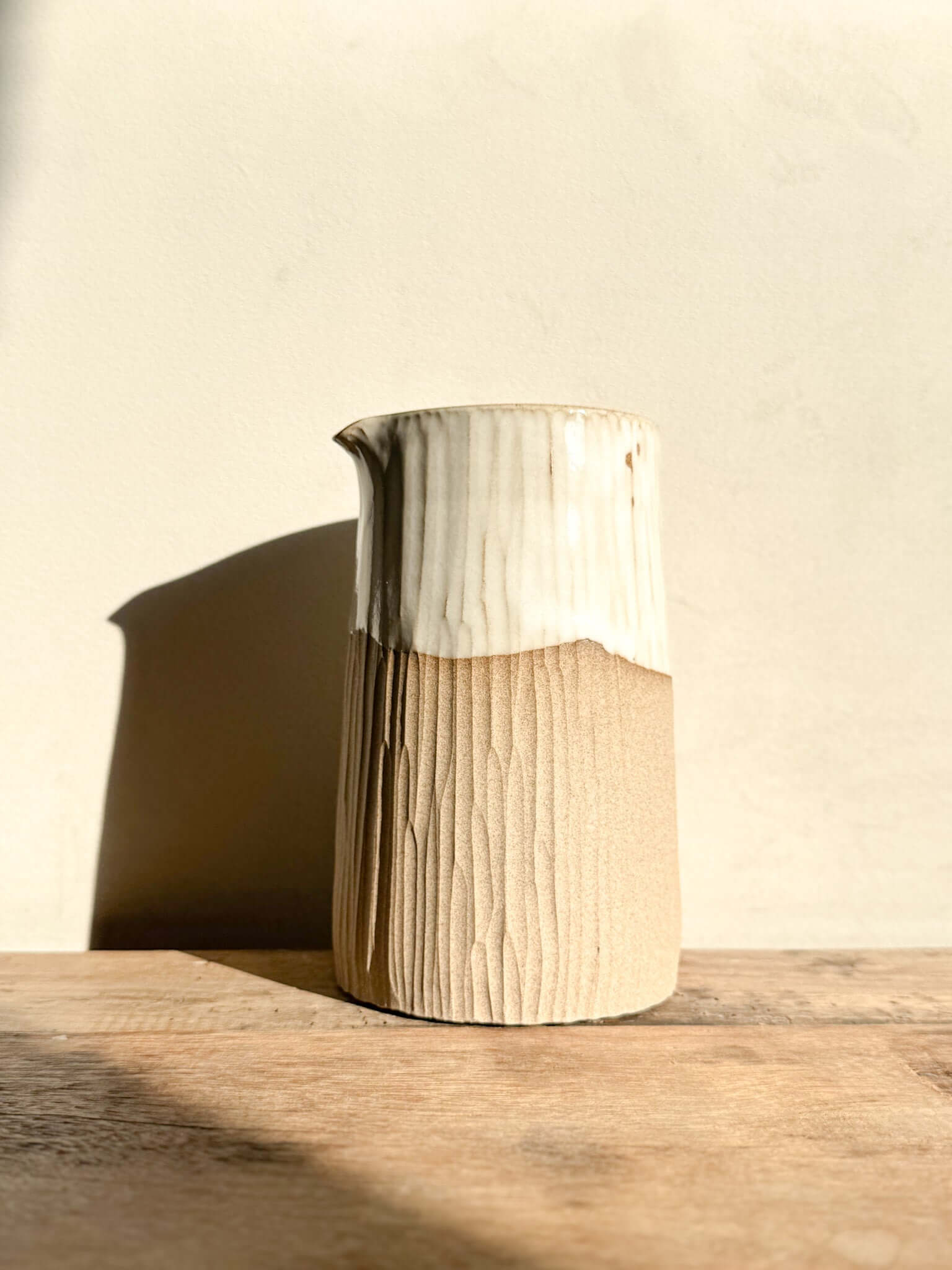 Medium vase jug from Yuki Series with hand-carved lines and glossy white glaze on top, showcasing natural texture and subtle elegance.