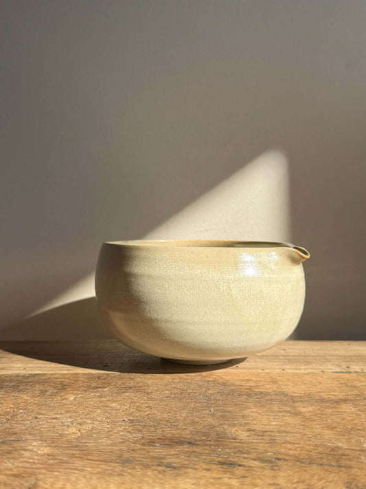 Katakuchi Matcha Bowl with Spout in Moonstone glaze on wooden surface, highlighting its soft, rounded design and smooth pouring spout.