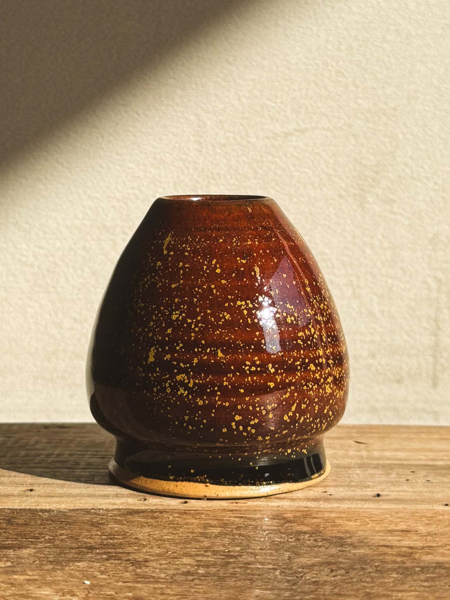 Amber glazed Matcha whisk holder with speckled design, perfect for maintaining bamboo Chasen shape and enhancing tea setup aesthetics.