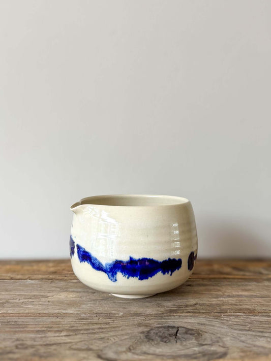 Katakuchi Matcha Bowl with cobalt blue glaze, featuring a spout from the Gosu Series. Unique splattered patterns on a rustic wooden surface.