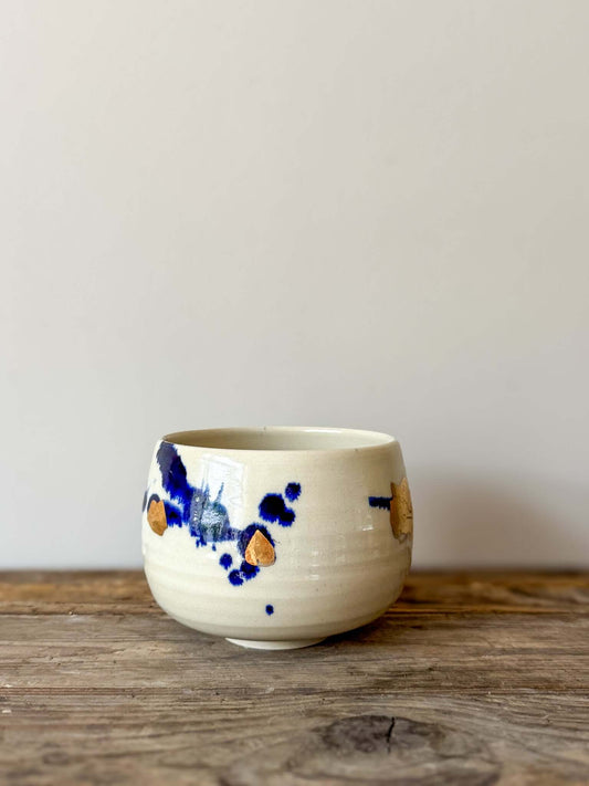 Rounded Matcha Bowl with cobalt glaze and hand-applied gold leaf, part of the Gosu Series. Elegant off-white ceramic with artistic detail.