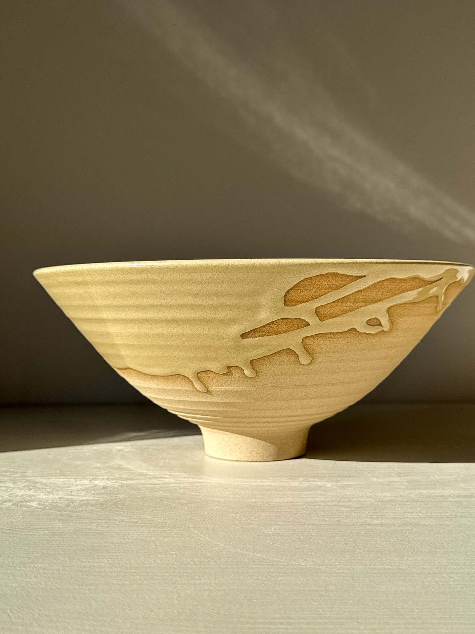 Side view of Medium Bowl - Inyo #01 with a sculptural design, raw exterior, and drip details in golden tones.