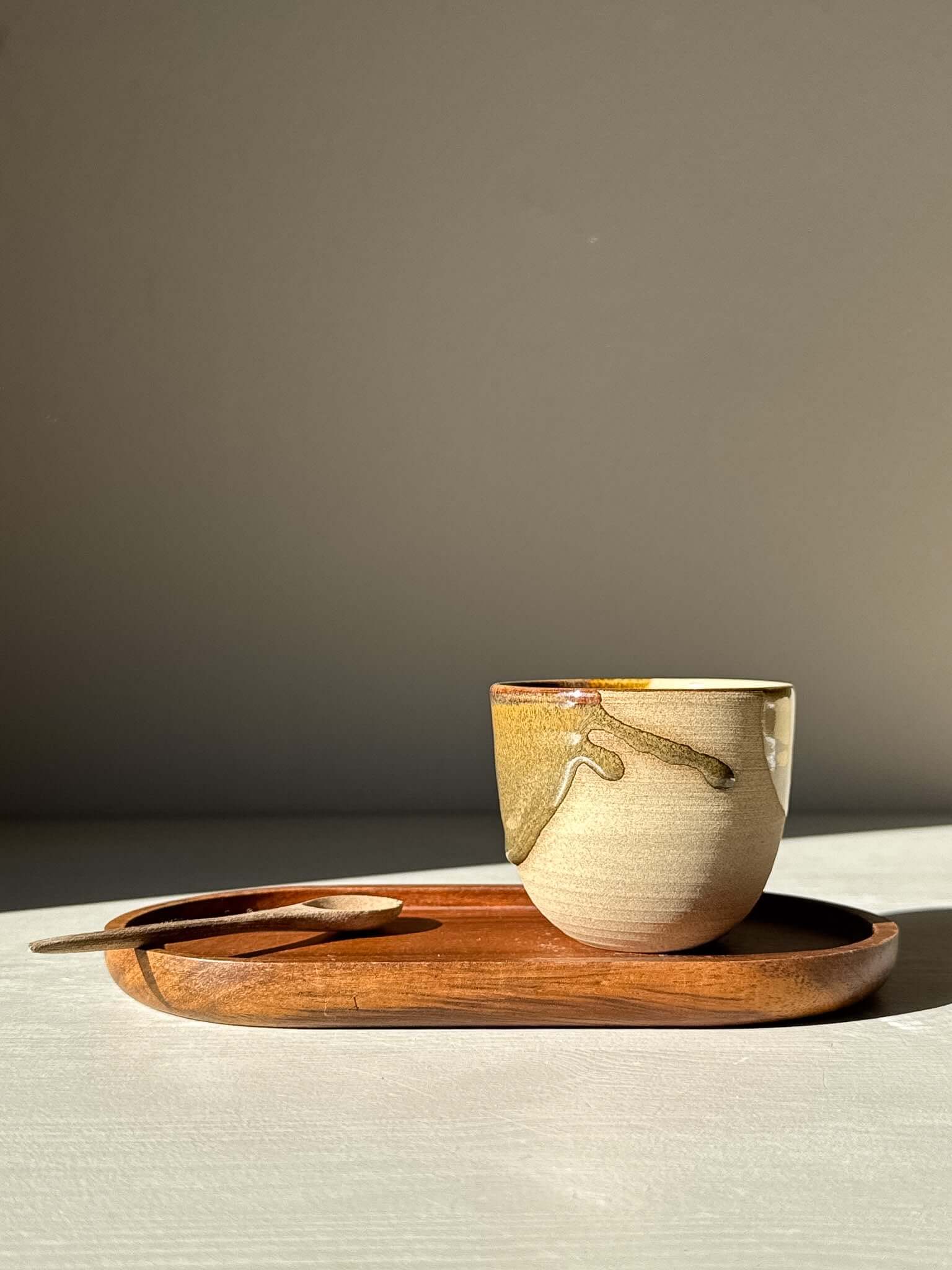 Espresso Cup - Inyo Series on a wooden tray with a spoon, showcasing earthy tenmoku glaze and warm clay.