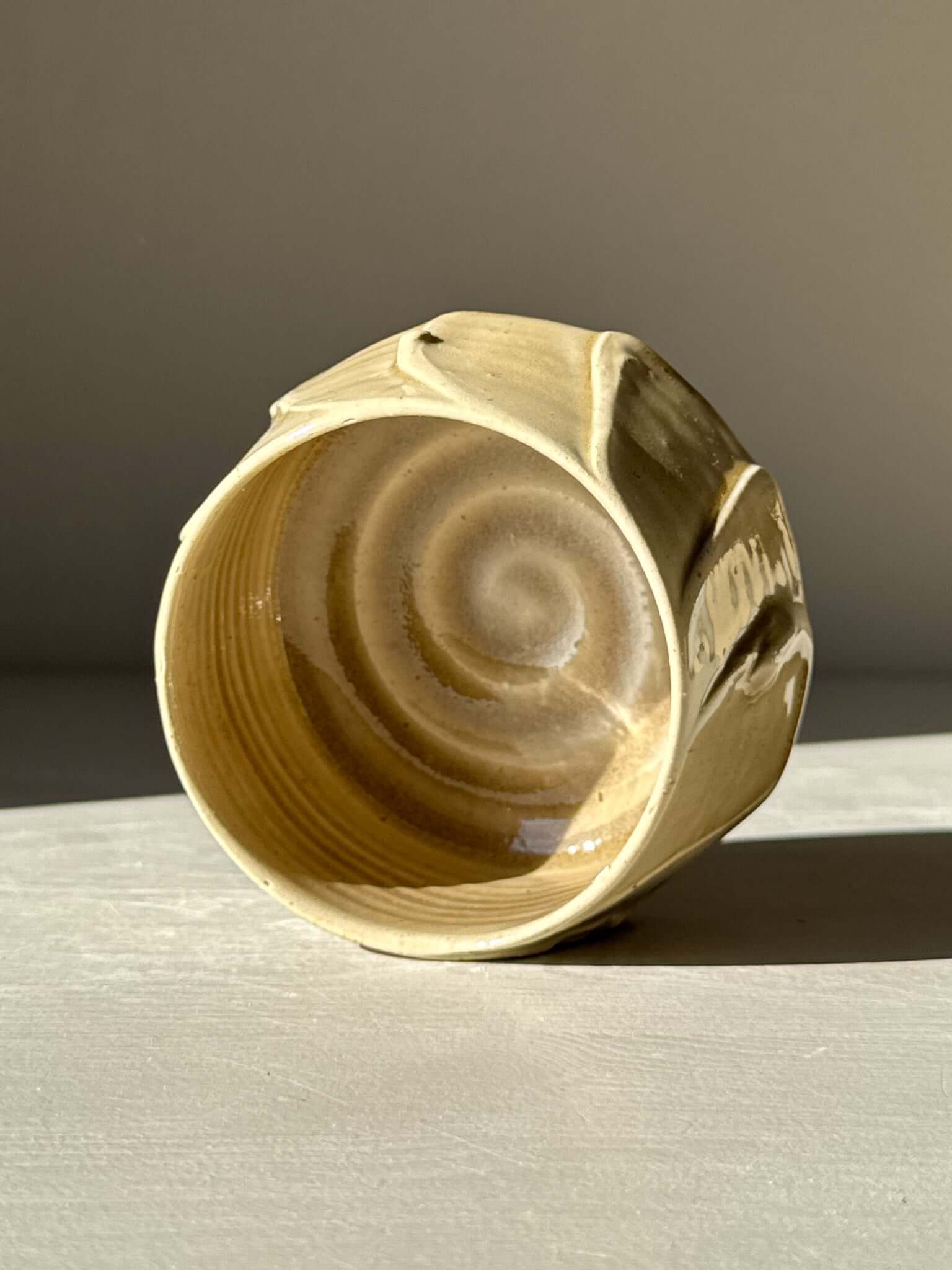 Yunomi Cup - Beige, a handmade ceramic cup with beige glaze, showcasing unique textures and natural swirl patterns from studio experimentation.