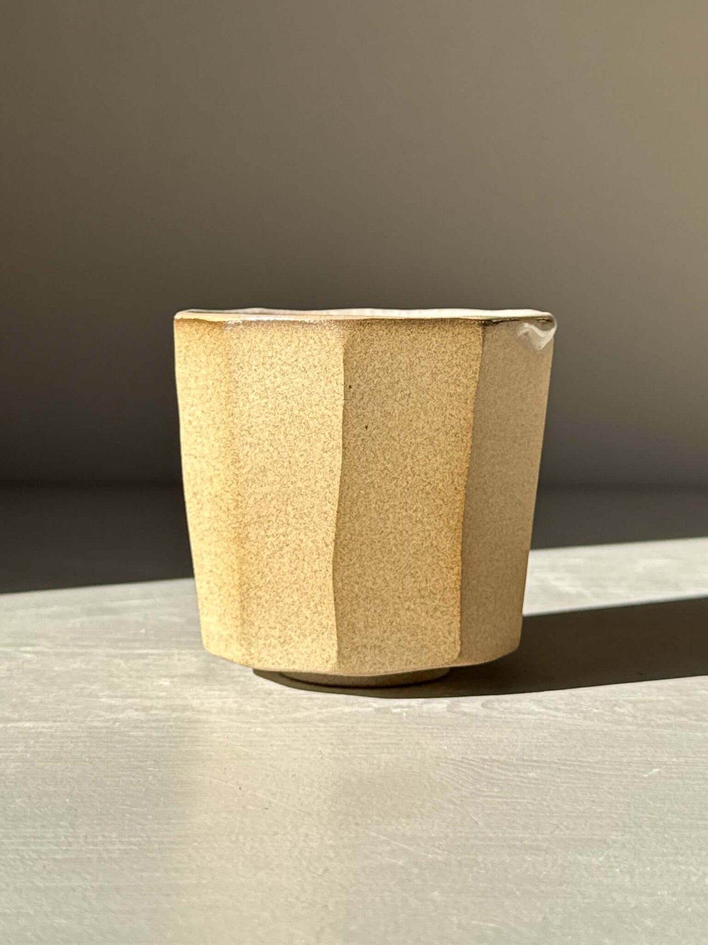 Faceted yunomi cup - Crackle Glaze with geometric form and natural clay texture in sunlight.