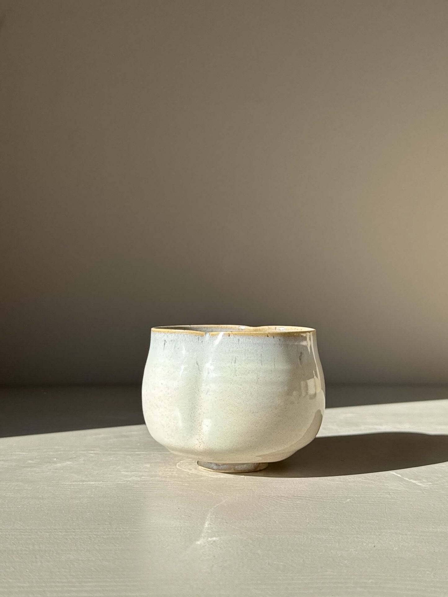 Yunomi Cup - Pale Blue ceramic with soft grey and warm clay tones, showcasing a rounded shape and organic folds.