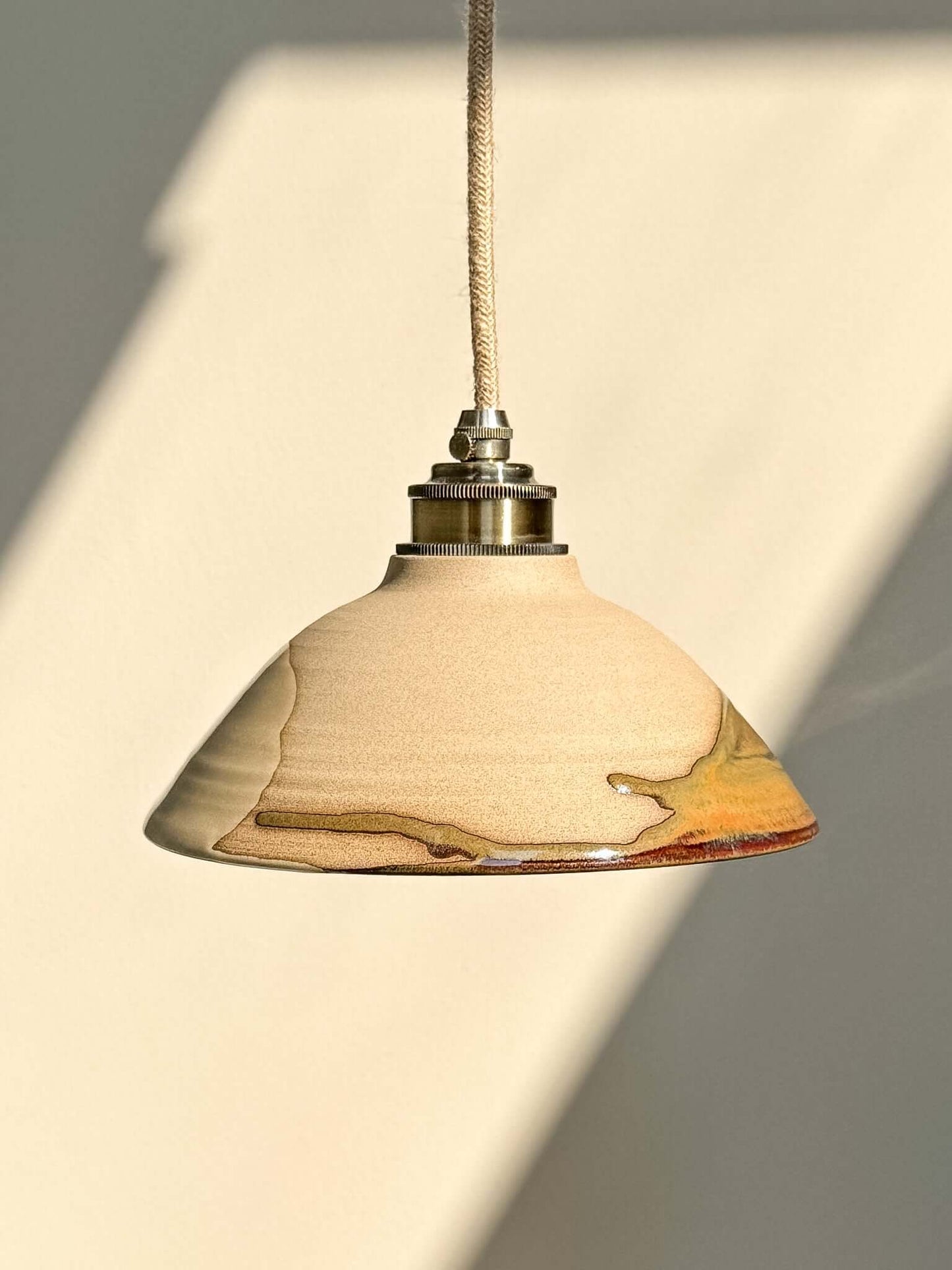 Ceramic Lamp Shade – Inyo #03 with glossy glaze, bronze and amber tones, showing natural surface and flowing drips under light.