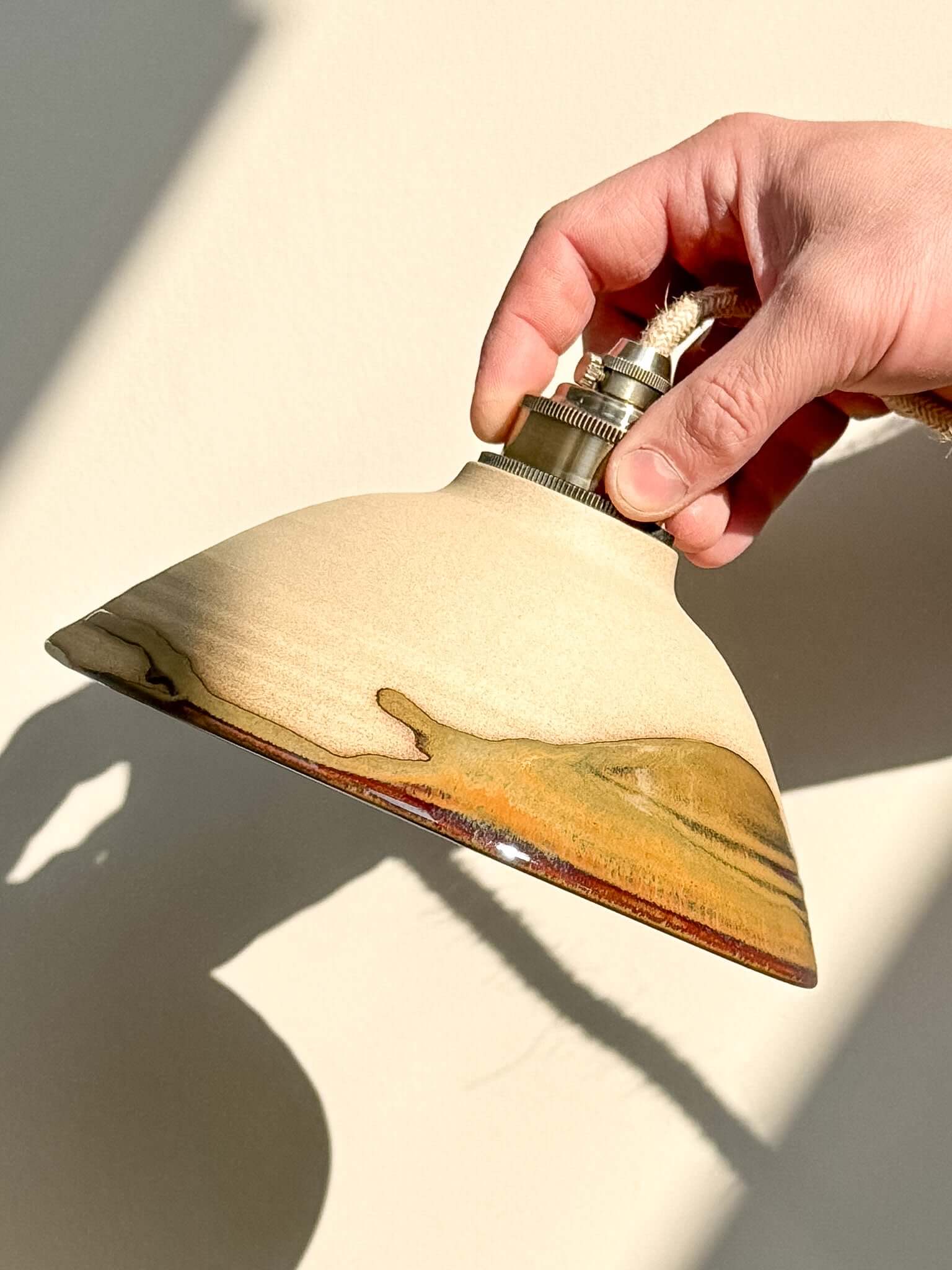 Hand holding Ceramic Lamp Shade – Inyo #03 with natural clay surface and glossy glaze drips.