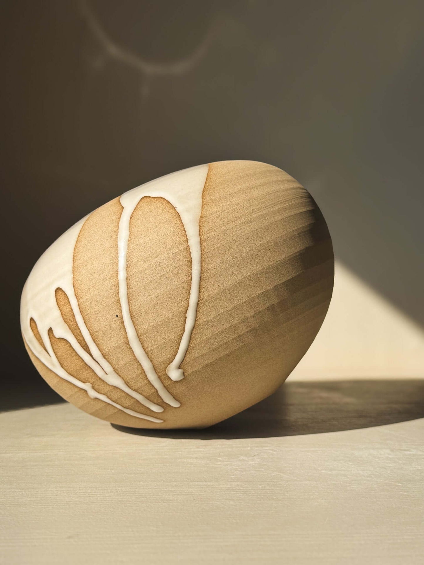 Handcrafted Orb Vase – #19 with unique glaze drips and organic patterns, showcasing a soft, spherical form perfect for a sculptural display.