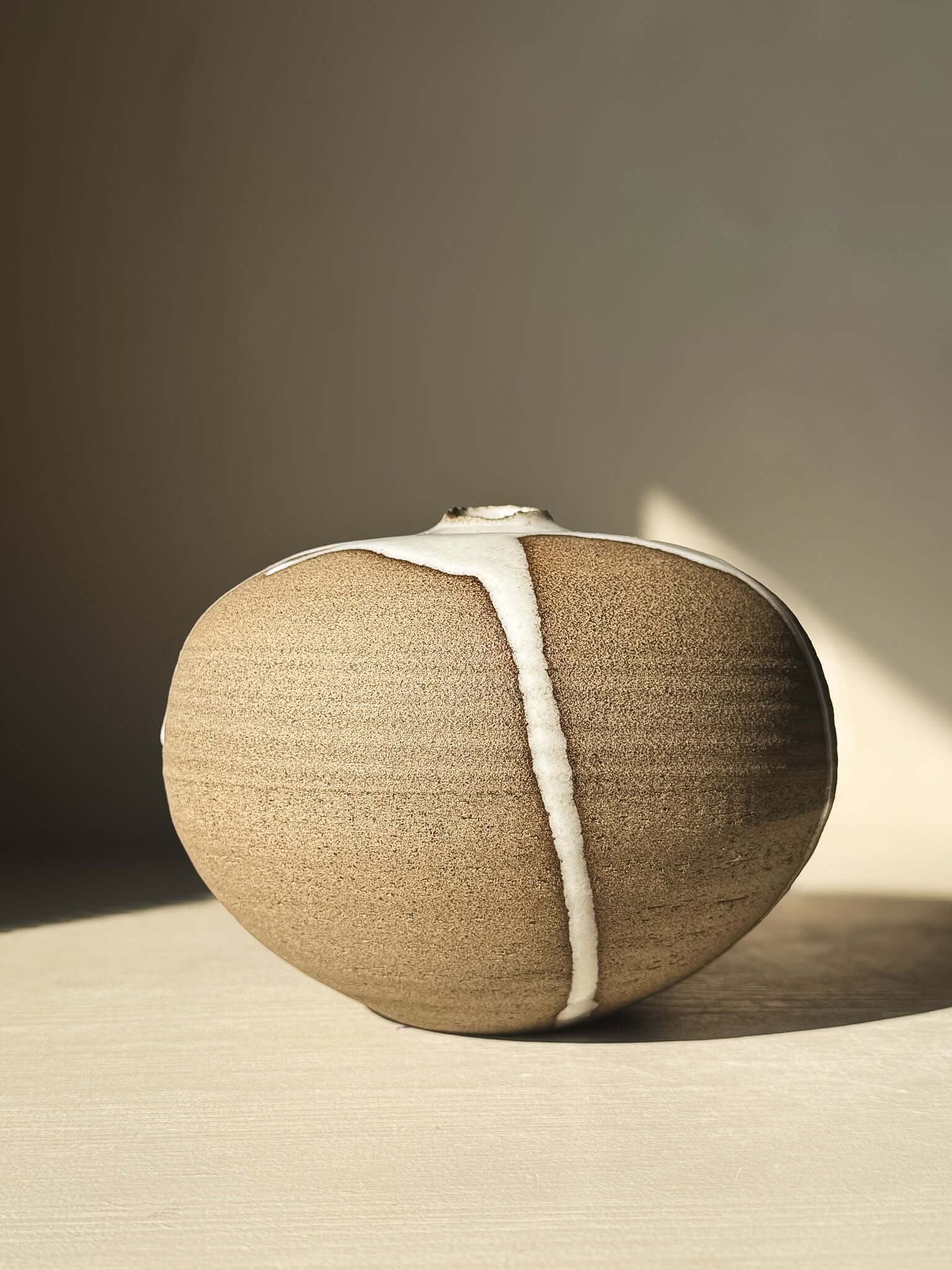Orb Vase – #17 with natural glaze drips on a soft spherical form, creating a unique sculptural presence.