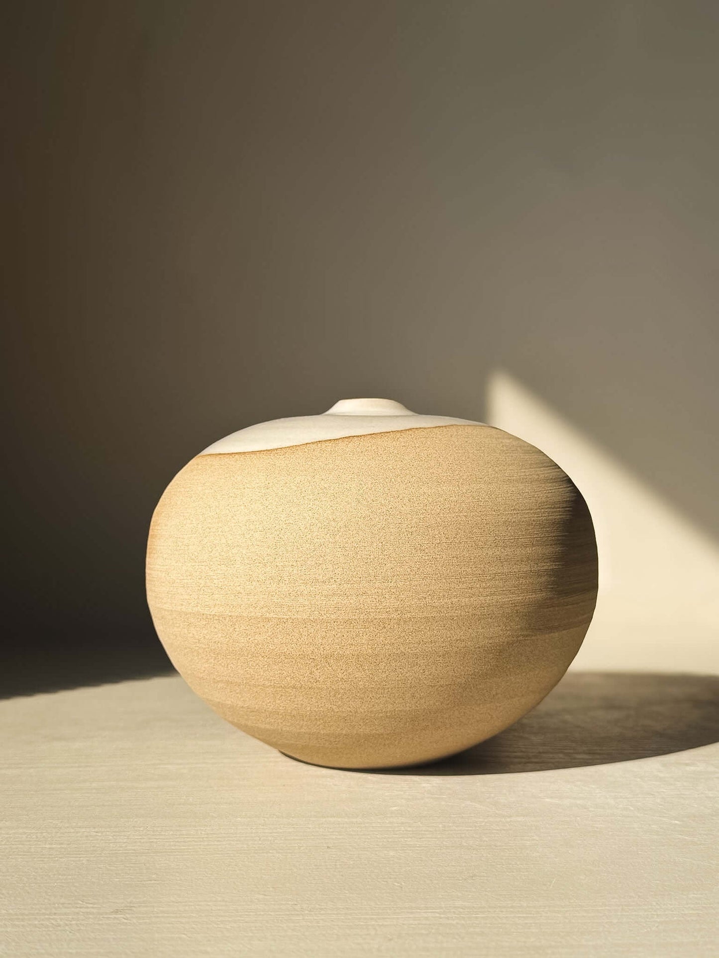 Orb Vase – #16 with unique glaze patterns and soft spherical design, showcasing handcrafted artistry in beige tones.