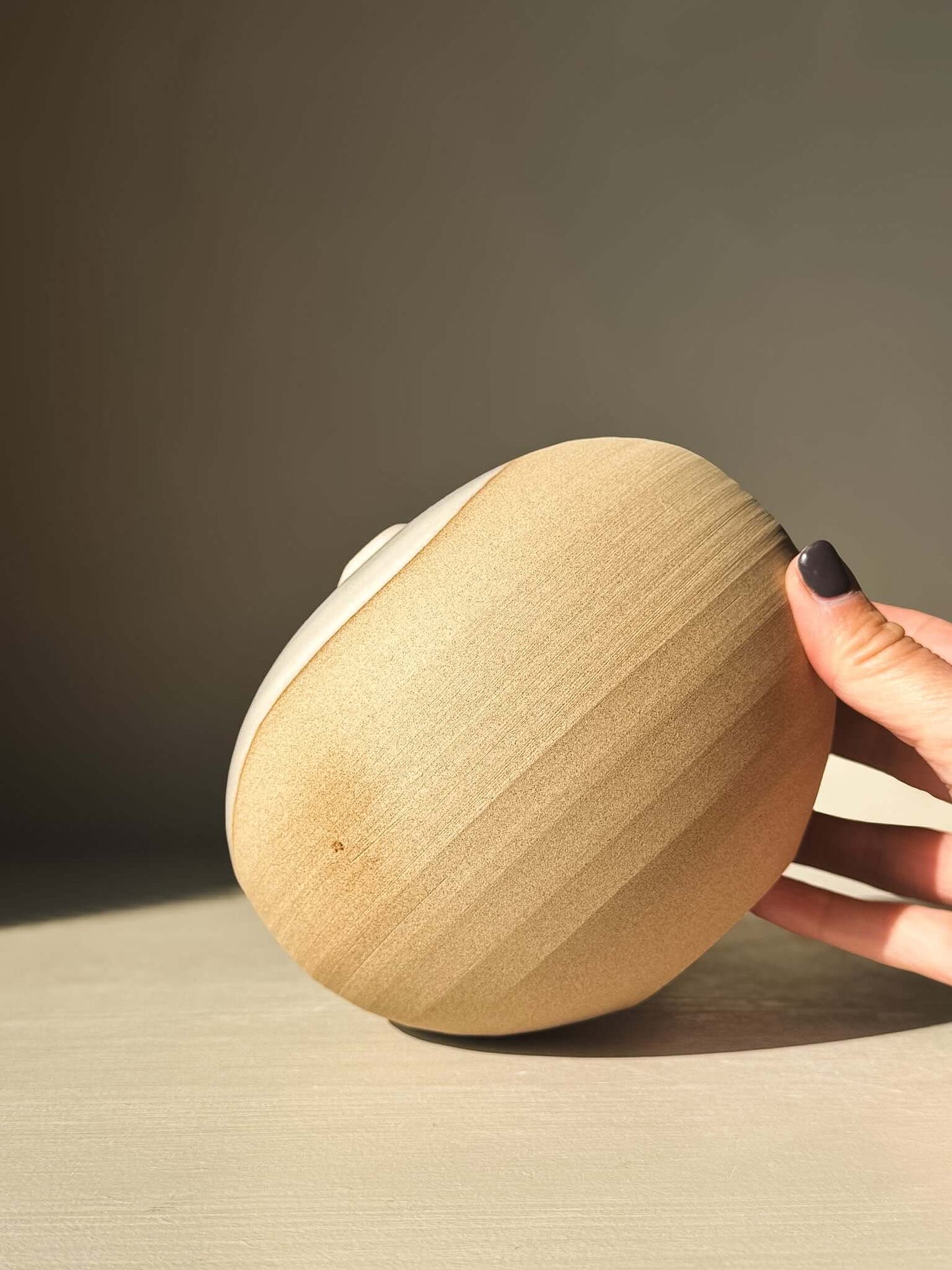 Side view of Orb Vase – #16 showcasing its unique clay texture and spherical form with natural glaze drips.