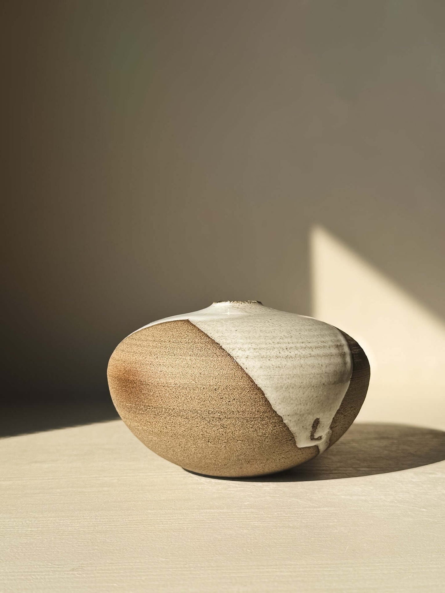 Elegant Orb Vase – #13 with natural glaze drips, showcasing unique clay patterns and sculptural spherical design.