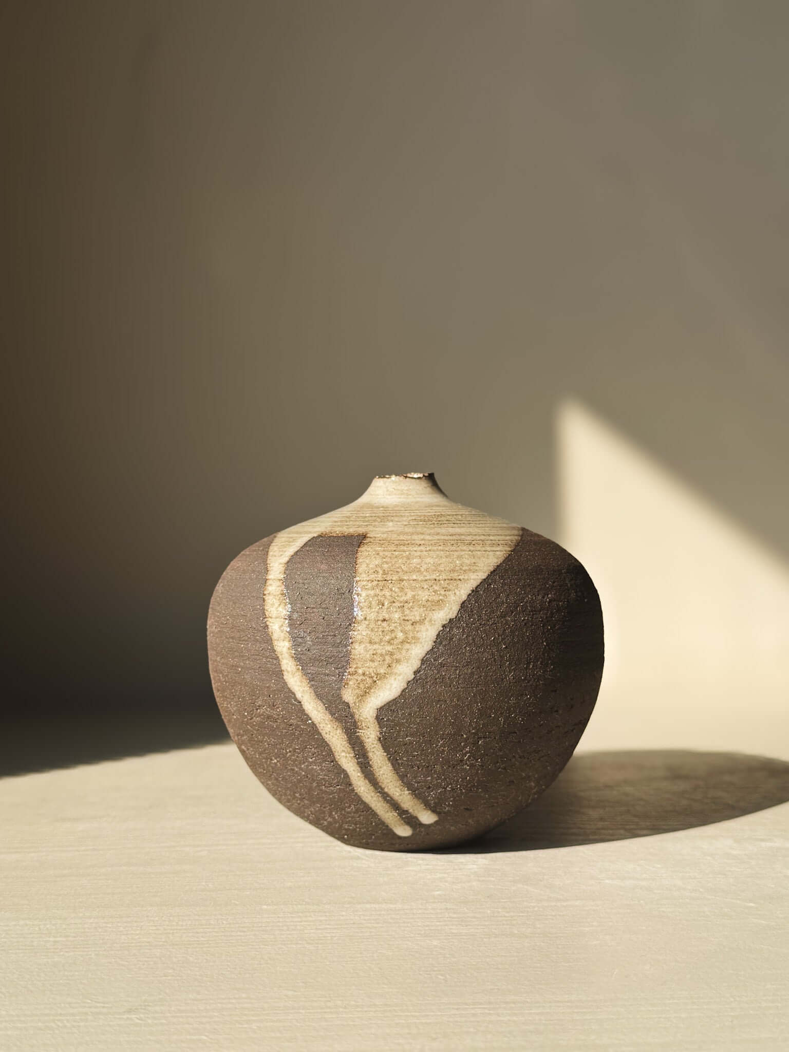 Orb Vase – #11 with unique glaze drips, sculptural round form, and organic patterns, part of a handcrafted vase collection.