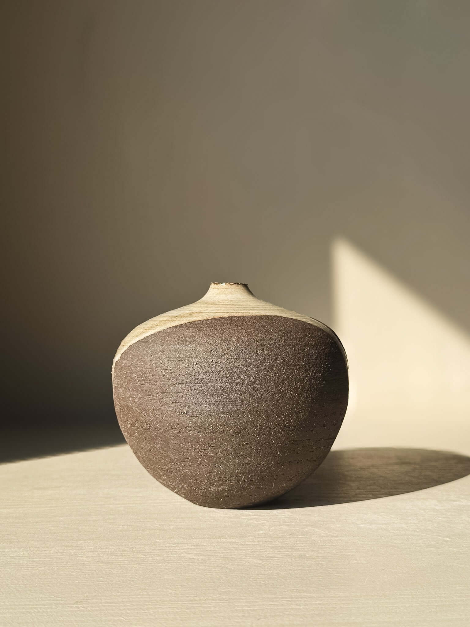 Orb Vase – #11 with rounded clay form and smooth glaze, showcasing unique drips and patterns for sculptural presence.