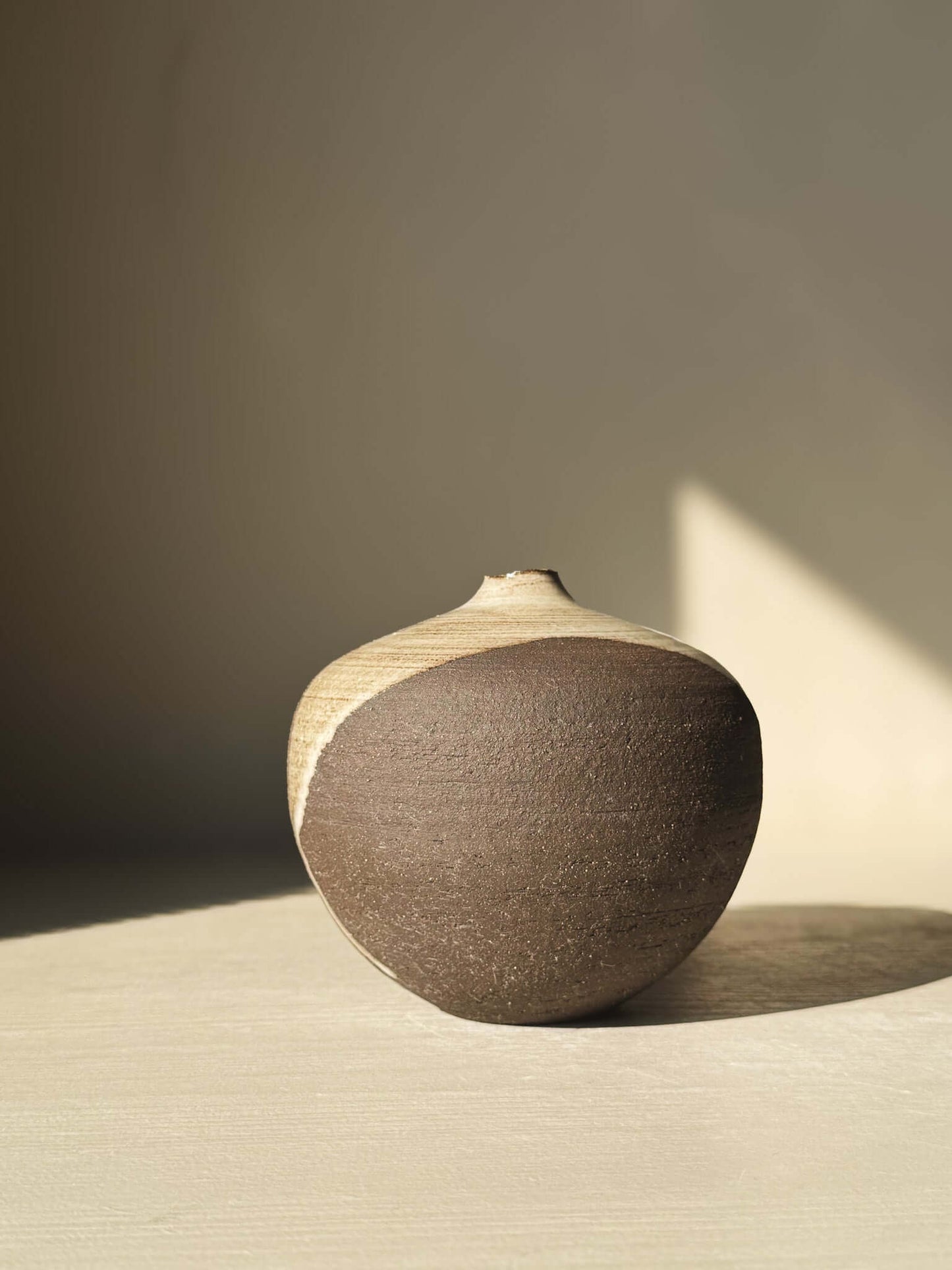 Handcrafted Orb Vase – #11 showcasing unique clay and glaze patterns in a rounded, sculptural form with a calm presence.