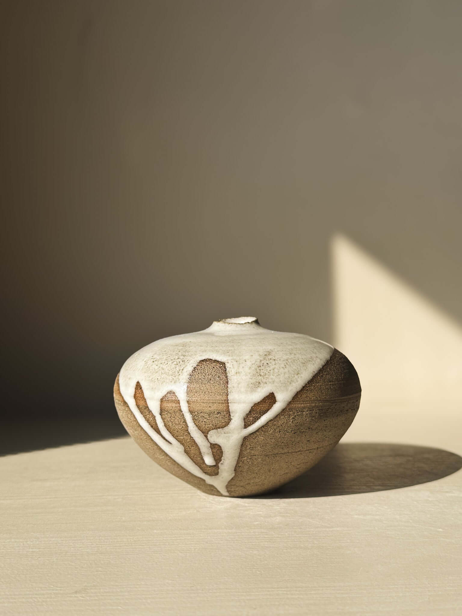 Orb Vase – #10 with unique glaze patterns and spherical form, showcasing its natural clay texture and artistic design in soft light.