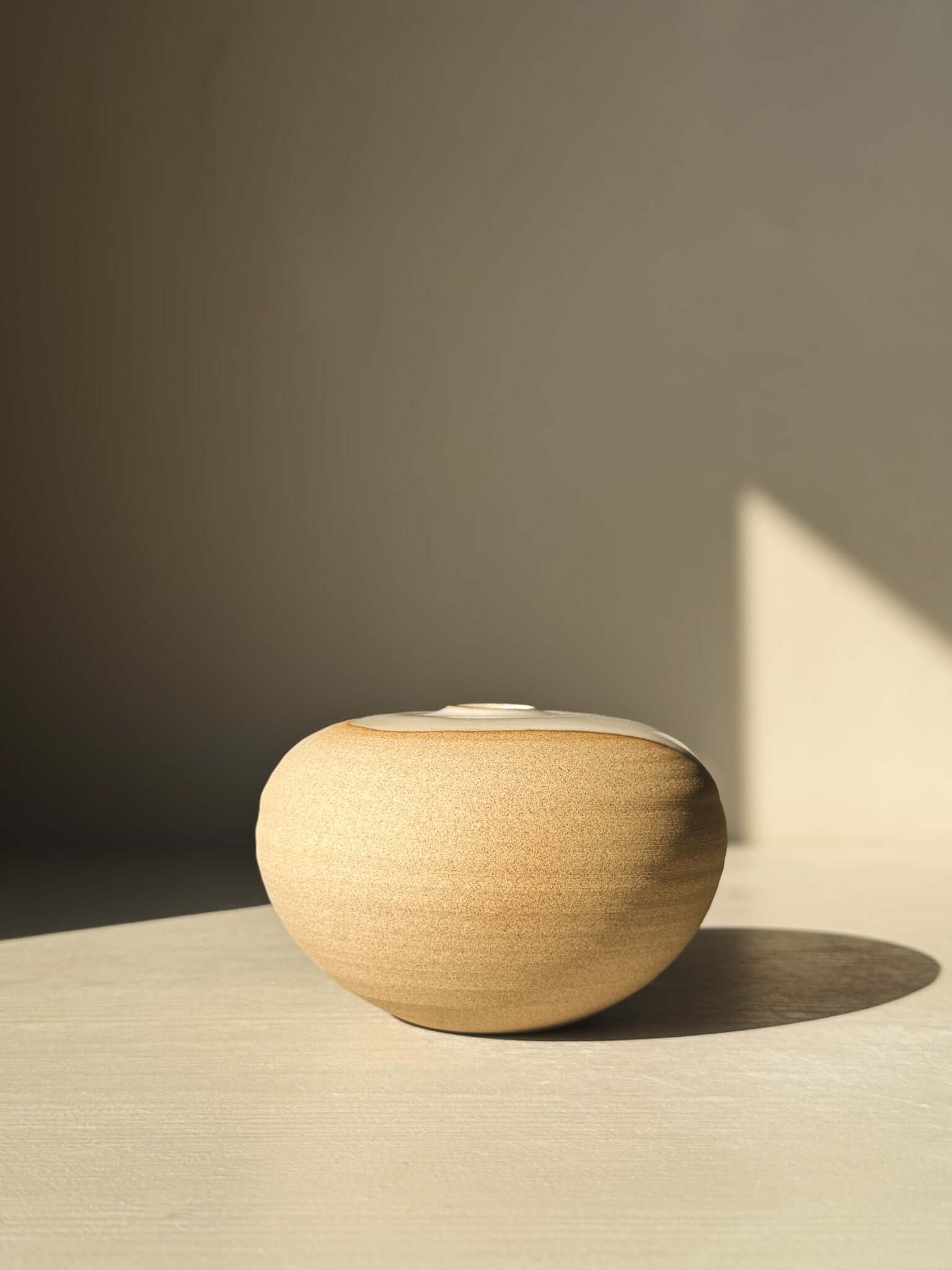 Orb Vase – #06 with unique glaze drips and rounded form, showcasing its sculptural presence in natural light.