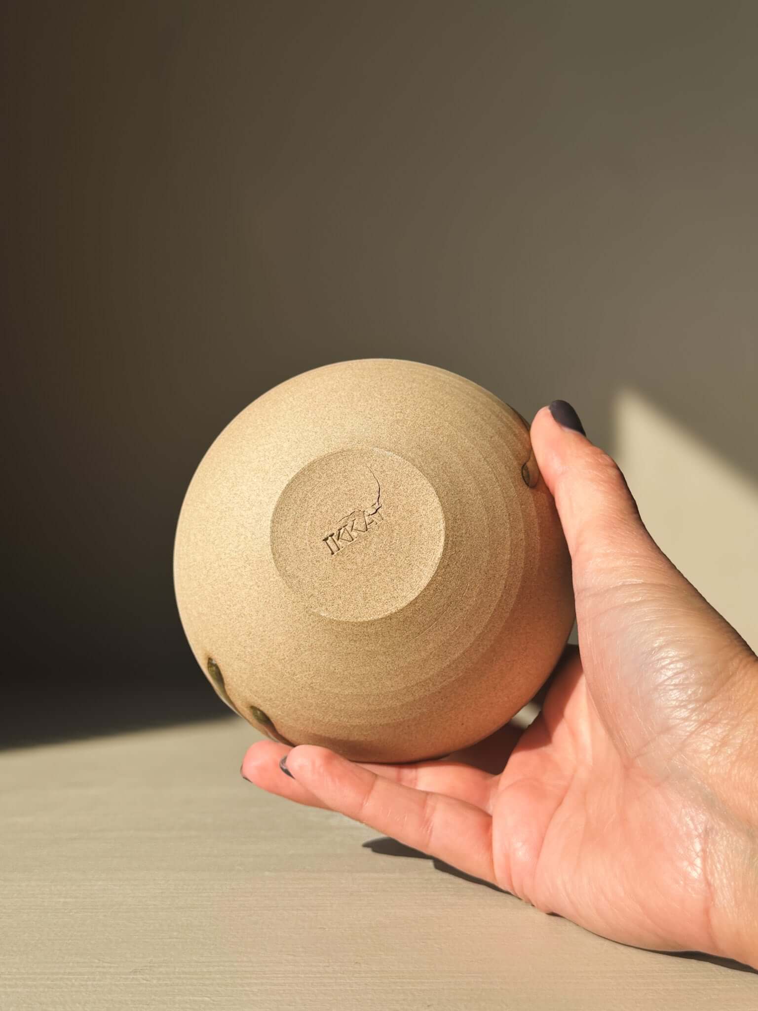 Person holding clay Orb Vase – #04 with unique glaze patterns.